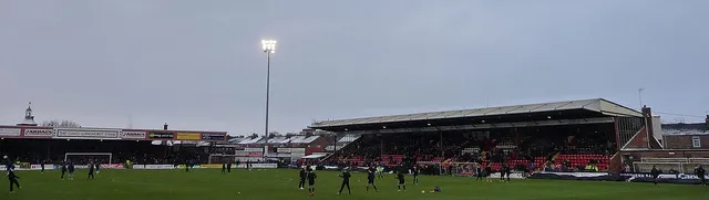 Ánh đèn đêm rọi sáng sân Bootham Crescent trong một trận đấu tối, tạo nên không khí huyền ảo.