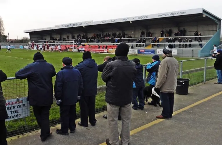 Cảnh sân Optima Stadium (Woodspring Stadium) trong một ngày có trận đấu, với khán đài và một phần sân cỏ