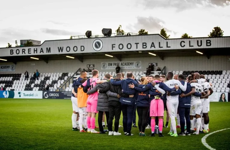 Đội hình Boreham Wood FC chụp ảnh trước khán đài chính tại sân Meadow Park, chuẩn bị cho trận đấu.