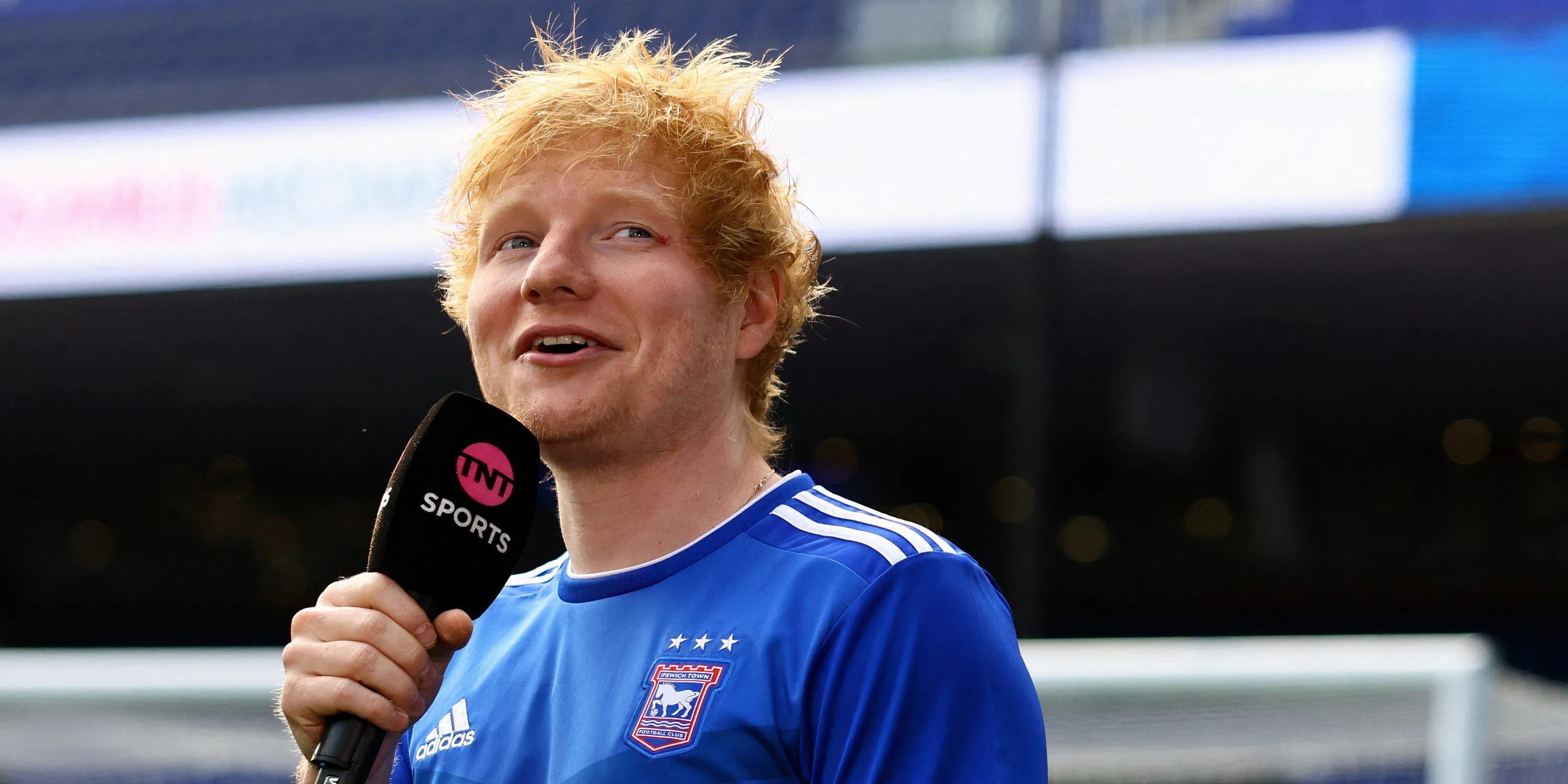 Ed Sheeran, ca sĩ nổi tiếng toàn cầu, mặc áo đấu Ipswich Town, thể hiện tình yêu và vai trò chủ sở hữu một phần CLB quê hương.
