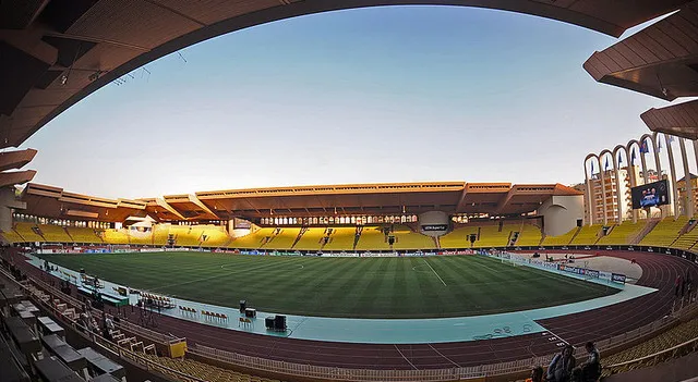 Góc nhìn rộng khán đài Stade Louis II với hàng ghế liên tục và không gian xanh xung quanh