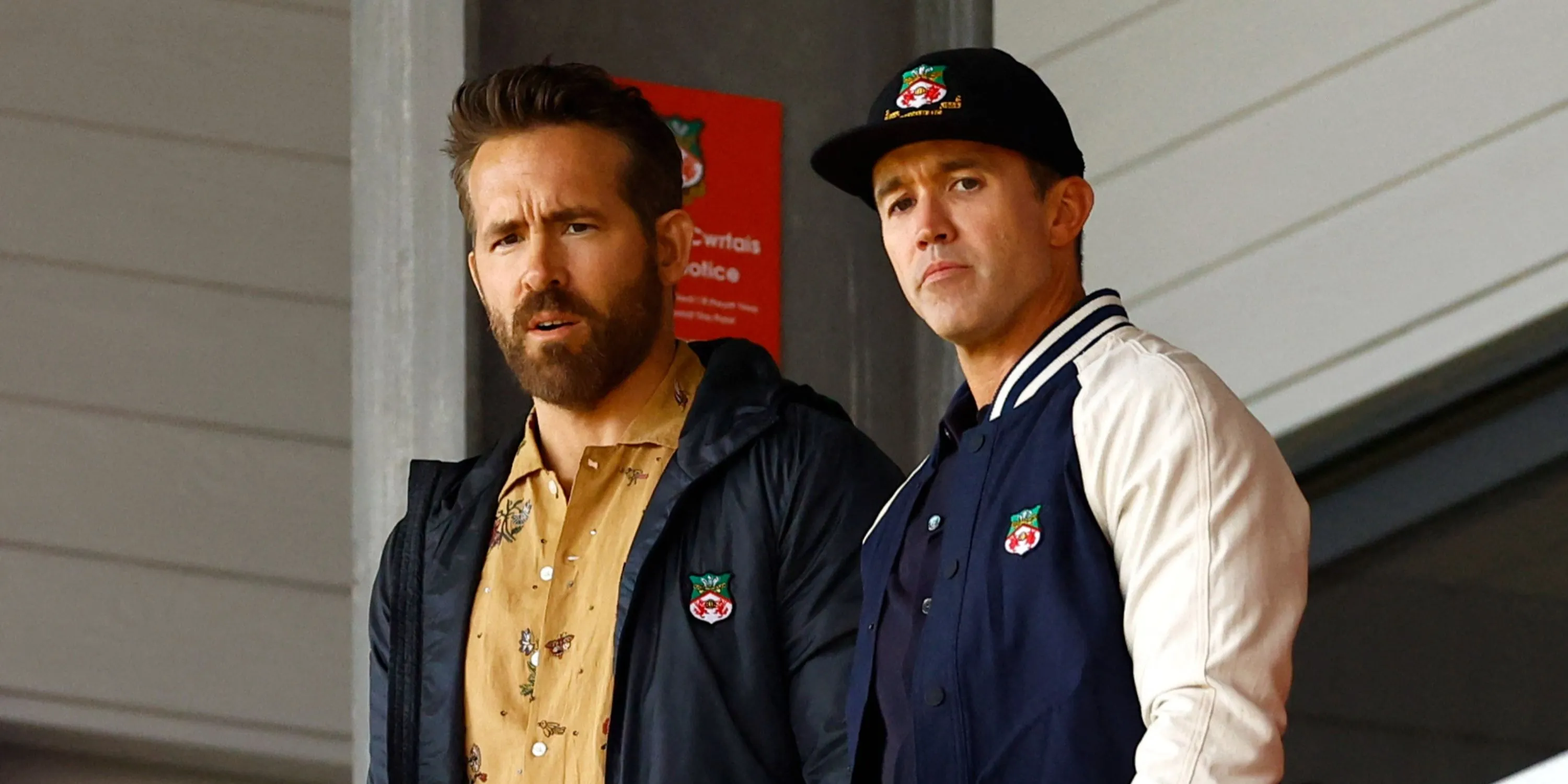Ryan Reynolds và Rob McElhenney ăn mừng cuồng nhiệt trên khán đài, biểu tượng cho thành công của họ với tư cách đồng sở hữu Wrexham AFC.