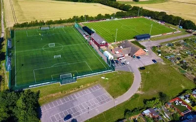 Sân vận động Bloomfields của Needham Market FC nhìn từ trên cao, biểu tượng của bóng đá Anh cấp thấp.