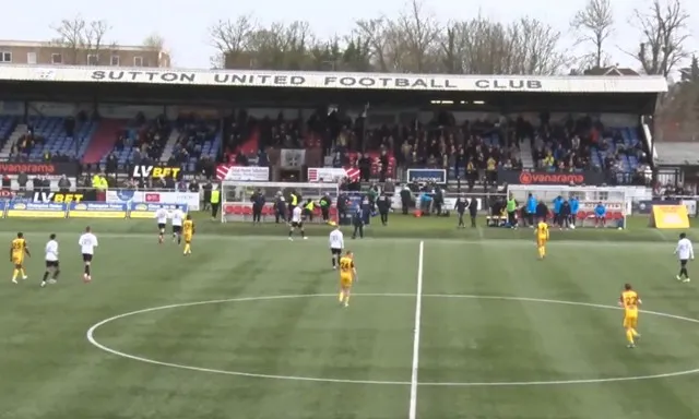 Trận đấu giữa Sutton United và Torquay United tại Gander Green Lane, không khí sôi động của bóng đá Anh cấp độ thấp