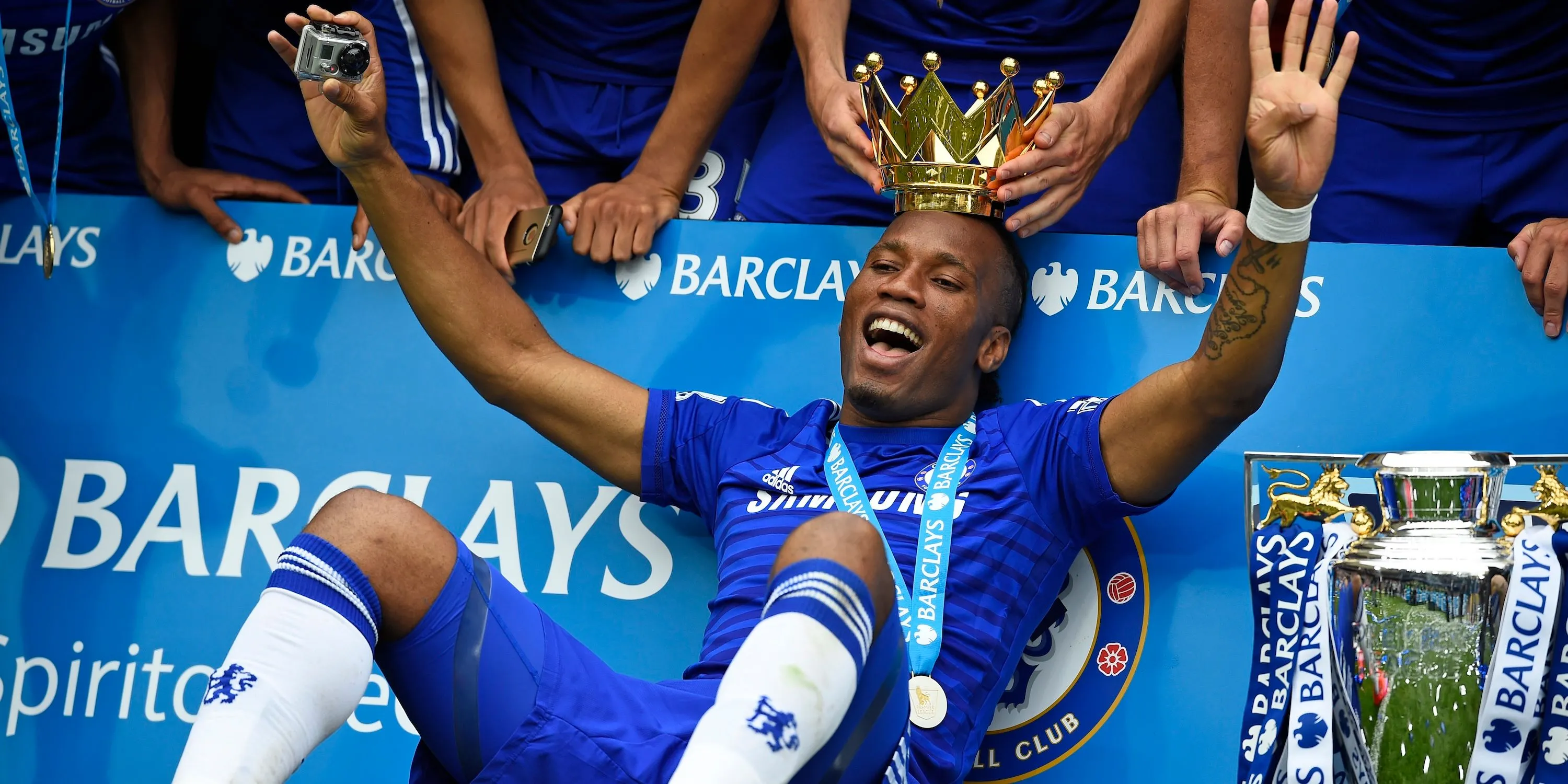 Didier Drogba ăn mừng danh hiệu Premier League cùng Chelsea, biểu tượng của sự tận hiến và thành công tại Stamford Bridge.