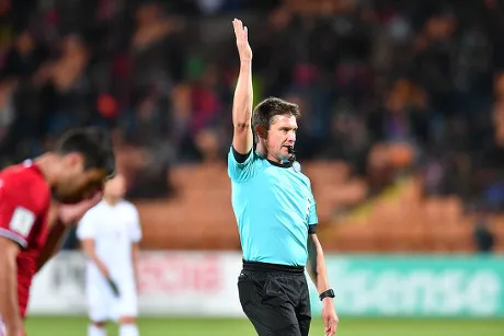 Trọng tài giơ một tay qua đầu khi thông báo tình huống đá phạt gián tiếp, cảnh báo tất cả cầu thủ trong vòng cấm