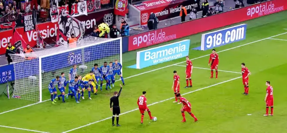 Trọng tài giơ tay báo hiệu đá phạt gián tiếp, tín hiệu rõ ràng cho cầu thủ và khán giả